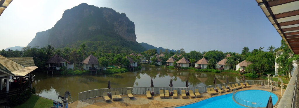 Cottages set around the lagoon, amongst the lush greenery and a majestic view of the limestone cliff